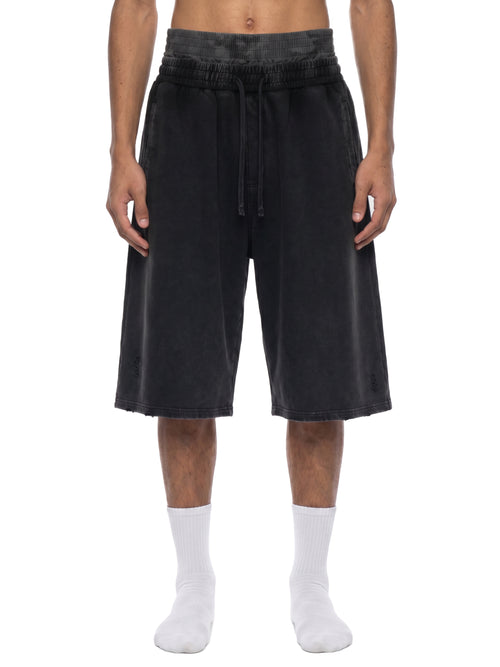 Black oversized drawstring shorts with ribbed waistband, styled with white socks for urban streetwear look