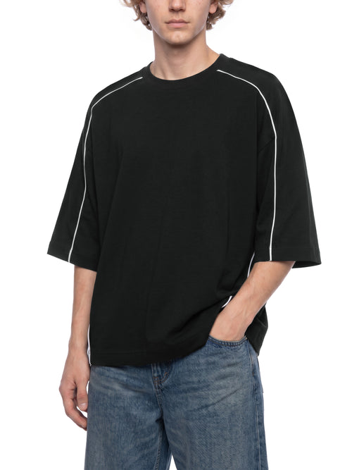 Black oversized streetwear tee with white side stripes, paired with blue jeans for urban style