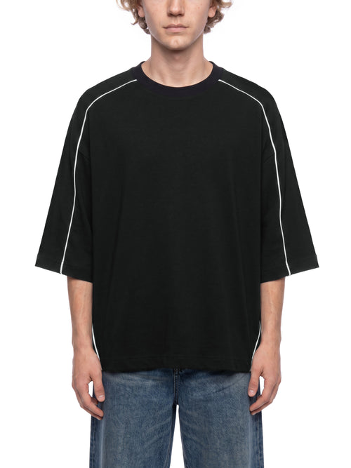 Black oversized streetwear tee with white side stripes, paired with blue jeans for urban style